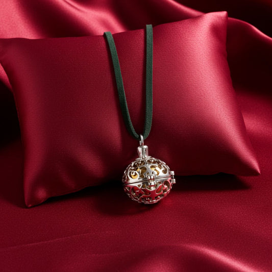 Decorative pendant on a green cord against a red satin background