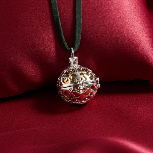 Decorative spherical pendant with intricate designs on a red fabric background