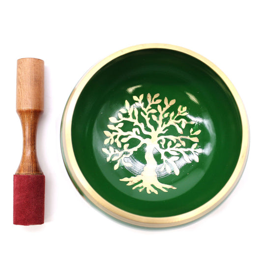 Green ceramic bowl with tree design and wooden mallet on white background