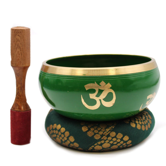 Green singing bowl with gold Om symbol and wooden striker on a white background