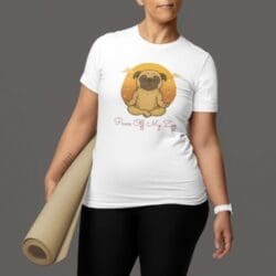 Wearing black leggings and the “Paws Off My Zen” white t-shirt featuring a meditating pug at sunset, a woman holds a rolled yoga mat. Her face is partly visible against a plain gray background.