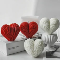 Four heart-shaped candles made with the Heart Candle Silicone Mold Handmade Gifts are arranged on white books and a ribbed stand. Swirling patterns add charm, one red candle is lit, and a minimalist background highlights these Valentine”™s Day creations.