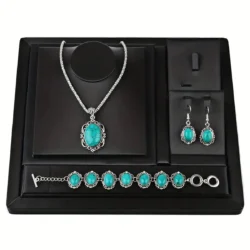 Turquoise jewellery set featuring necklace, bracelet, and earrings on black display tray
