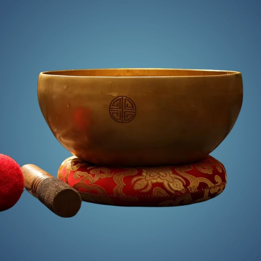 Handcrafted Nepal Full Moon Singing Bowl resting on a patterned red cushion with a wooden mallet beside it.