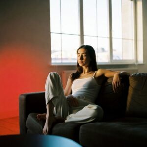woman resting on a sofa and window behind