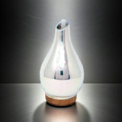 The Infinity Mirror Aroma Diffuser – 3D LED Effect (USB) features a pear-shaped, glass body with a pearlescent finish and sits on a round wooden base, emitting soft white 3D LED light that gently illuminates its metallic, brushed-steel background.